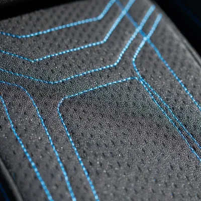 Close-up of a gaming chair's material, highlighting its breathable fabric and robust stitching, indicating high quality and comfort.
